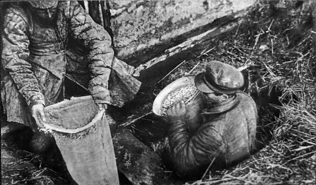 Работники органов госбезопасности извлекают из ямы спрятанное зерно, 1932 год. Фото из архива Государственного музея политической истории России