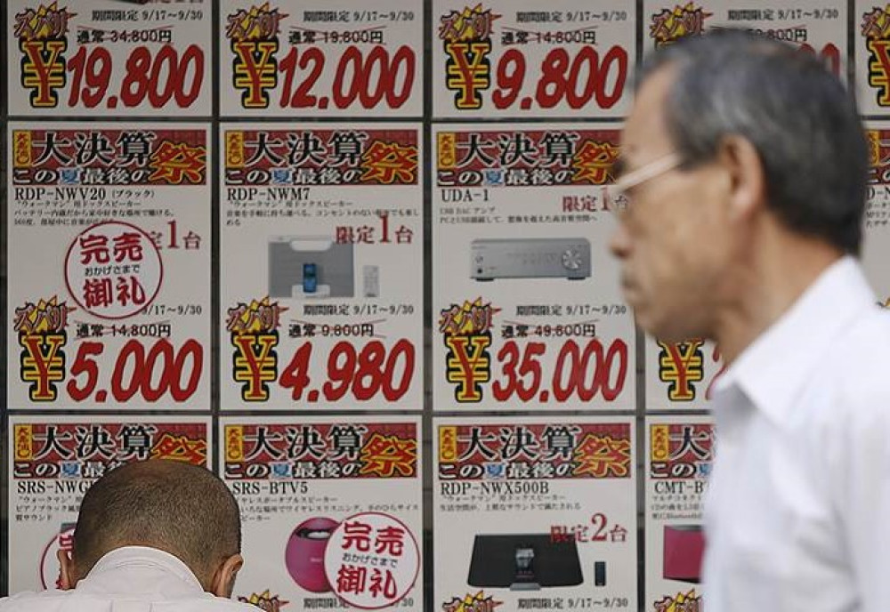 В 2015 году после небольшого всплеска товары опять начали дешеветь. Объявление о снижении цен в магазине электроники в Токио. (Фото: Reuters)